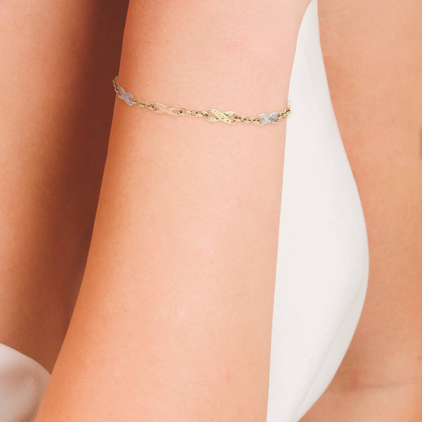 Pulsera eslabón combinado motivo infinitos en oro tres tonos 14 kilates.