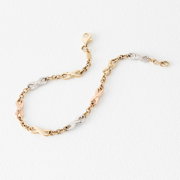 Pulsera eslabón combinado motivo infinitos en oro tres tonos 14 kilates.