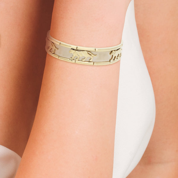 Pulsera de arillo ovalada abierta motivo felinos en oro dos tonos 14 kilates.