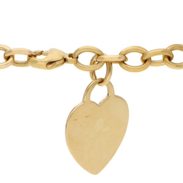 Pulsera eslabón cruzado con colgante motivo corazón firma Tiffany & Co en oro amarillo 18 kilates.