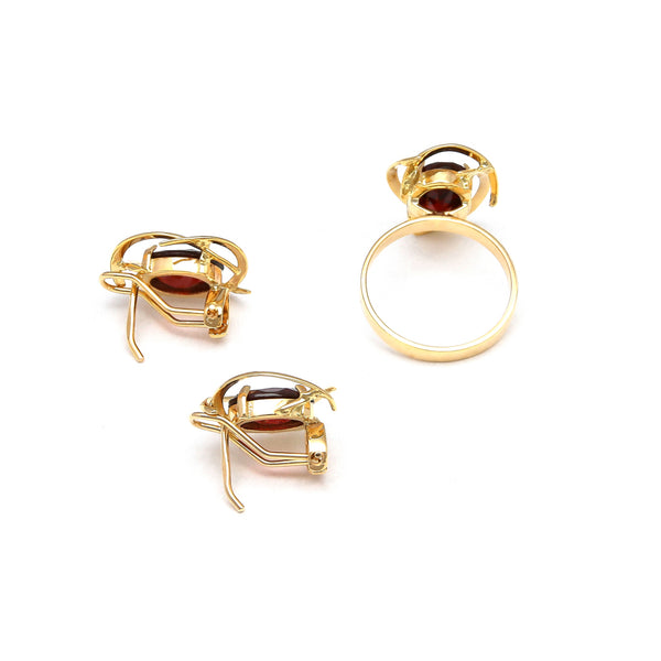 Juego de anillo y aretes calados con granates en oro amarillo 14 kilates.