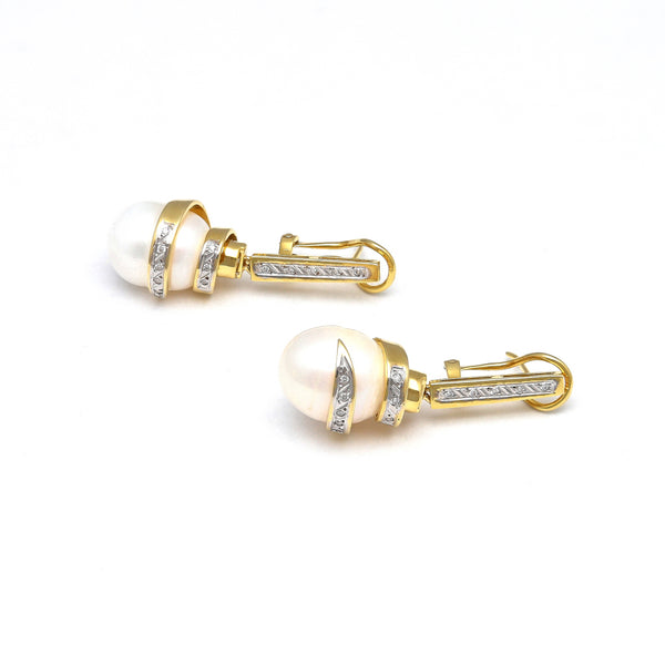 Aretes estilizados con colgantes, diamantes y perlas calabazo en oro amarillo 14 kilates.