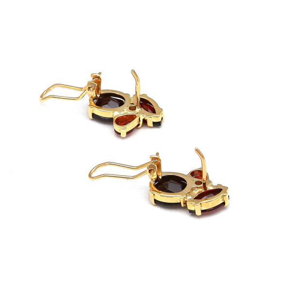 Aretes estilizados con diamantes y granates en oro amarillo 14 kilates.