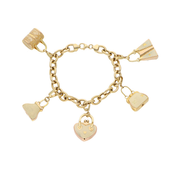 Pulsera eslabón cruzado con dijes motivo bolso y esmalte en oro amarillo 14 kilates.