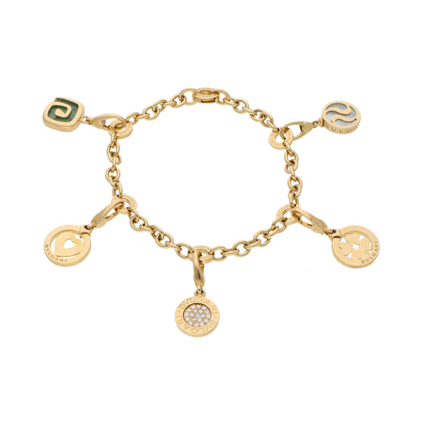 Pulsera eslabón cruzado con aplicaciones, dijes, diamantes, madre perla y esmalte firma Bvlgari en oro amarillo 18 kilates.