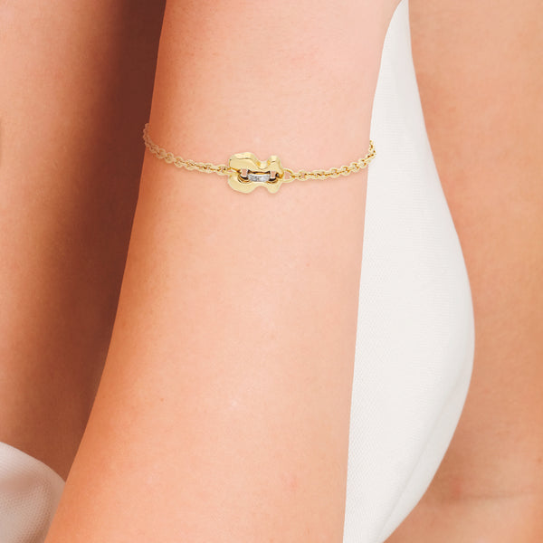 Pulsera eslabón cruzado con aplicación motivo oso y diamantes firma Tous en oro amarillo 18 kilates.