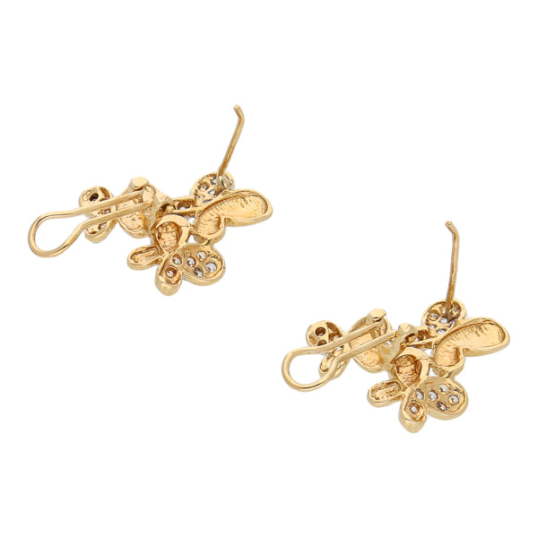 Aretes estilizados motivo mariposas, juego de anillo y dije diseño especial motivo floral con circonias en oro amarillo 14 kilates.