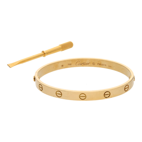 Pulsera rígida articulada motivo tornillos simulados firma Cartier en oro amarillo 18 kilates.