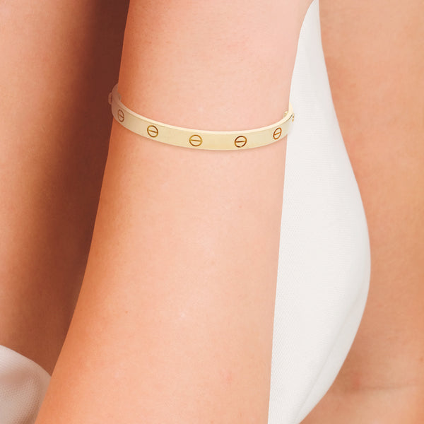 Pulsera rígida articulada motivo tornillos simulados firma Cartier en oro amarillo 18 kilates.