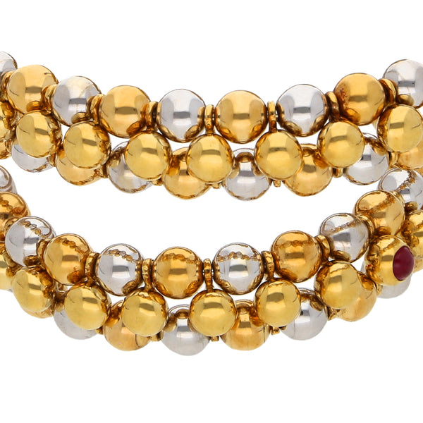 Pulsera de arillo abierta con diamantes, esmeraldas y rubíes en oro dos tonos 18 kilates.