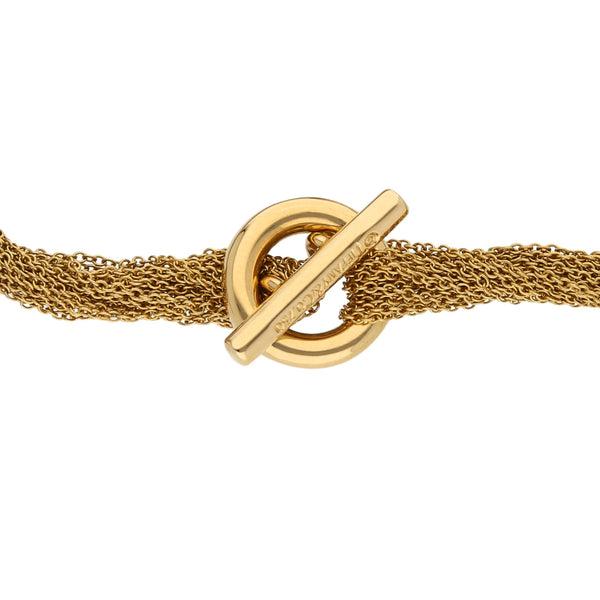 Pulsera trece hilos eslabón cruzado con aplicacion firma Tiffany & Co. en oro amarillo 18 kilates.