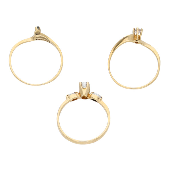 Tres anillos estilizados con sintéticos en oro amarillo 10 kilates.