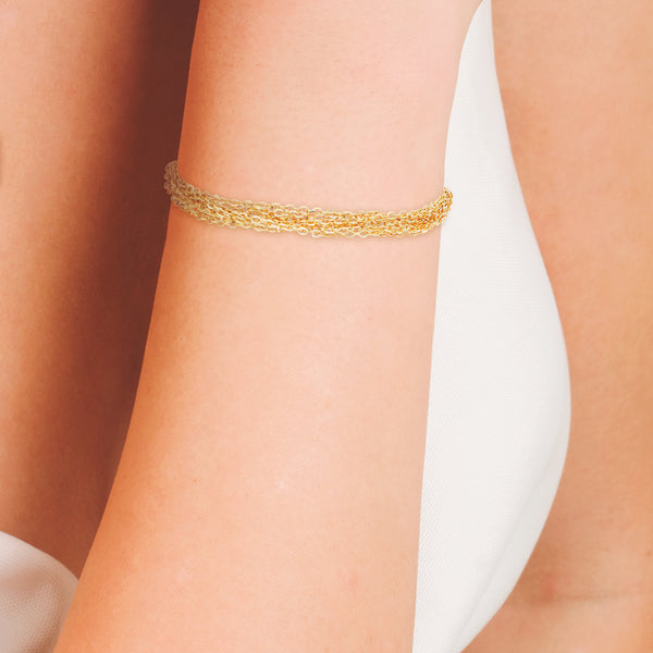 Pulsera ocho hilos eslabón cruzado con aplicaciones y sintéticos en oro amarillo 10 kilates.