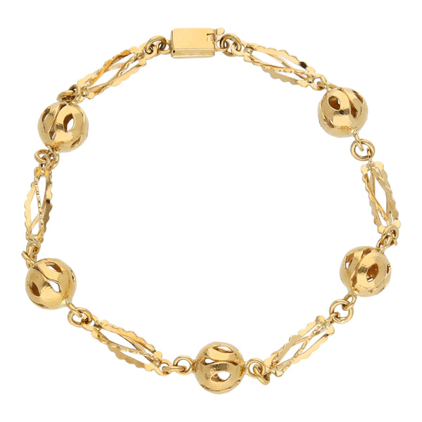 Pulsera eslabón combinado con esferas caladas en oro amarillo 18 kilates.