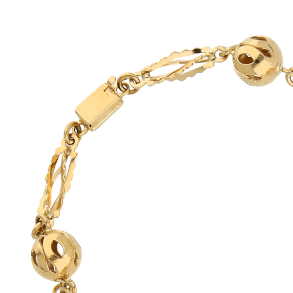 Pulsera eslabón combinado con esferas caladas en oro amarillo 18 kilates.