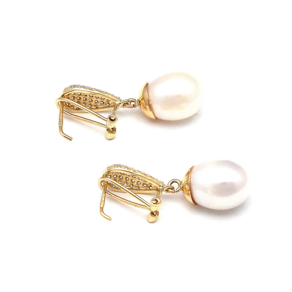 Aretes estilizados con perlas calabazo y circonias en oro amarillo 14 kilates.