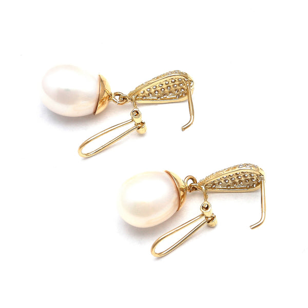 Aretes estilizados con perlas calabazo y circonias en oro amarillo 14 kilates.