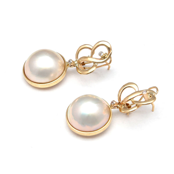 Aretes calados con colgantes, medias perlas y circonias en oro amarillo 14 kilates.