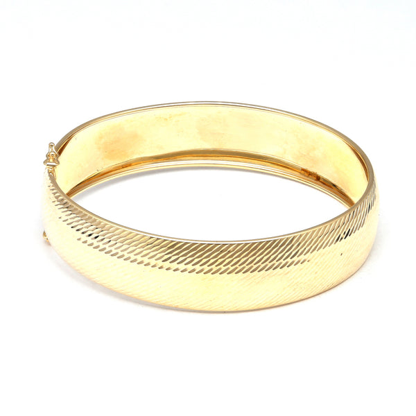 Pulsera de arillo ovalada martillada en oro amarillo 14 kilates.