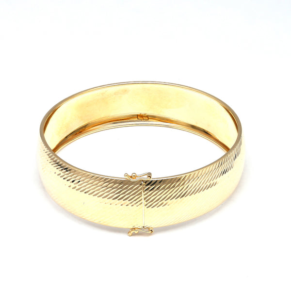 Pulsera de arillo ovalada martillada en oro amarillo 14 kilates.