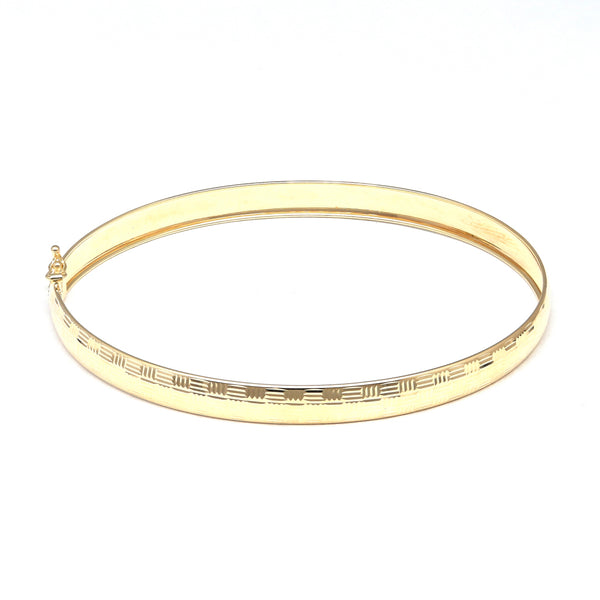 Pulsera de arillo ovalada labrada en oro amarillo 14 kilates.