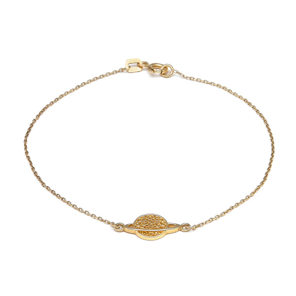 Pulsera eslabón cruzado con aplicación motivo saturno en oro amarillo 14 kilates.