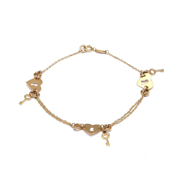 Pulsera eslabón combinado con aplicaciones motivo corazones con llave en oro amarillo 14 kilates.