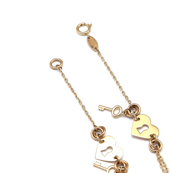 Pulsera eslabón combinado con aplicaciones motivo corazones con llave en oro amarillo 14 kilates.