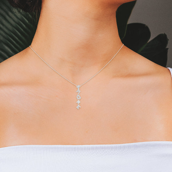 Juego de gargantilla eslabón cruzado con dije y aretes diseño especial motivo letras y corazones con diamantes en oro blanco 18 kilates.