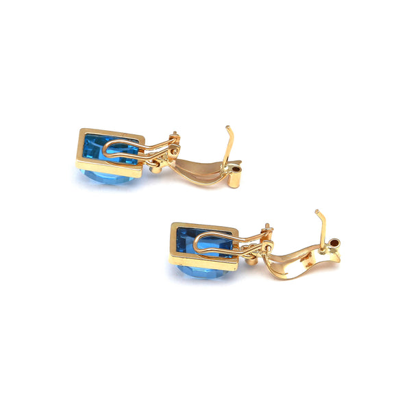 Juego de anillo y aretes estilizados con topacios London blue y circonias en oro amarillo 14 kilates.