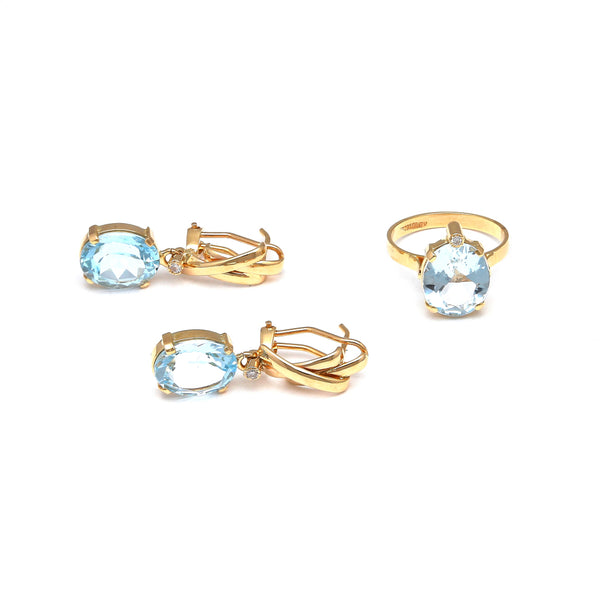 Juego de anillo y aretes estilizado con diamantes y topacios sky blue en oro amarillo 14 kilates.