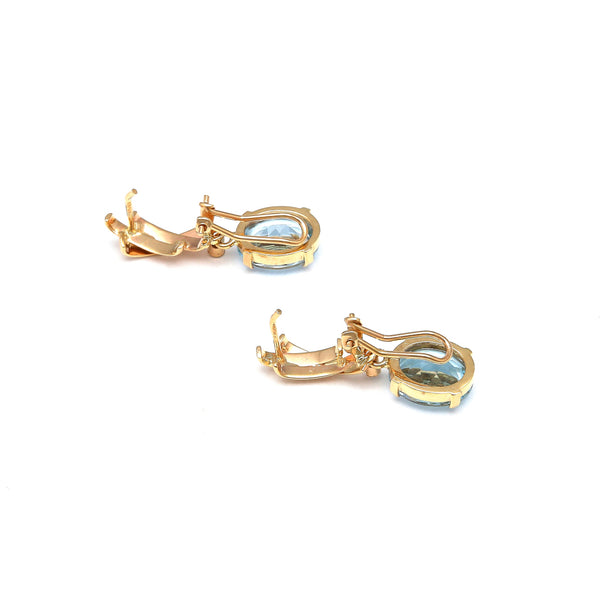 Juego de anillo y aretes estilizado con diamantes y topacios sky blue en oro amarillo 14 kilates.