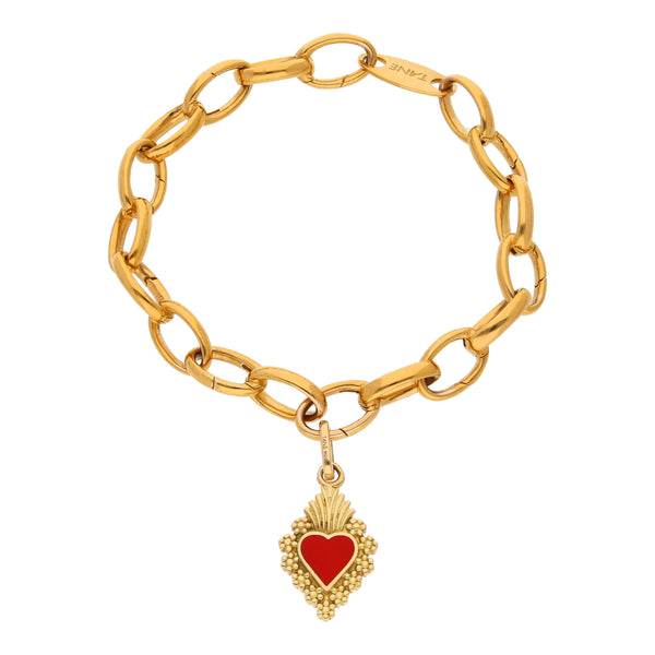 Pulsera eslabón cruzado con colgante motivo corazón y esmalte firma Tane en oro amarillo 18 kilates.