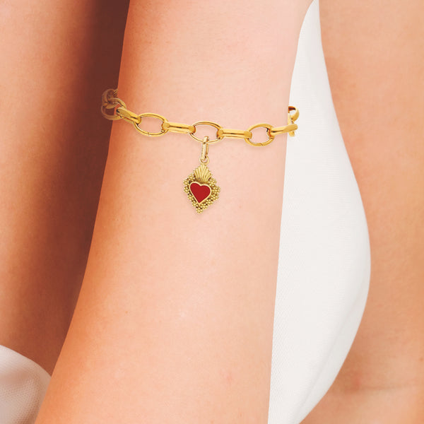 Pulsera eslabón cruzado con colgante motivo corazón y esmalte firma Tane en oro amarillo 18 kilates.