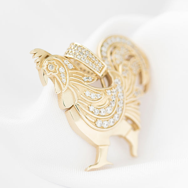 Dije diseño especial motivo gallo con circonias en oro amarillo 14 kilates.