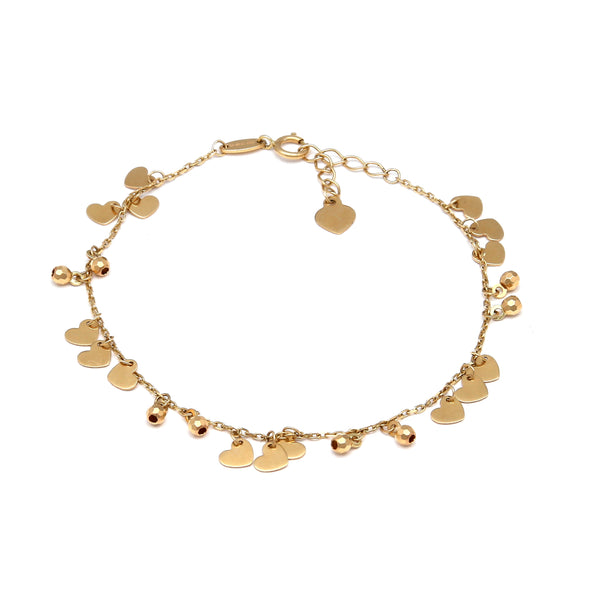 Pulsera eslabón cruzado con colgantes motivo corazones y esferas en oro amarillo 14 kilates.