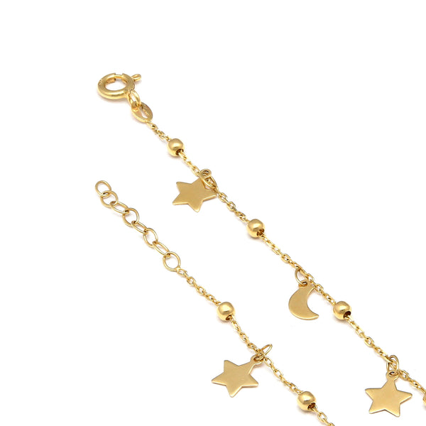 Pulsera eslabón cruzado con esferas y colgantes motivo lunas y estrellas en oro amarillo 14 kilates.