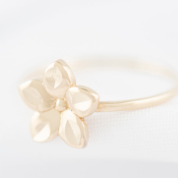 Anillo liso motivo flor en oro amarillo 14 kilates.