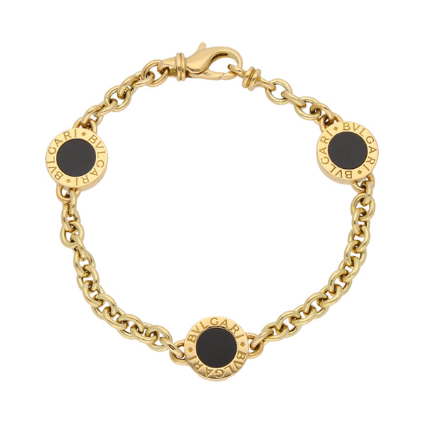 Pulsera eslabón cruzado con aplicaciones y ónix firma Bvlgari en oro amarillo 18 kilates.